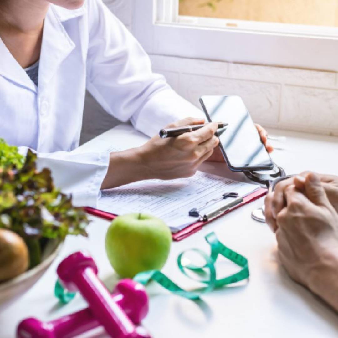 A person pointing to a phone surrounded by health paraphenalia